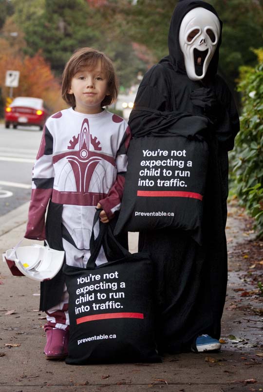 Picture of kids in costum holding special trick-or-treat bags