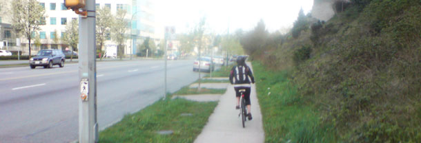 Woman riding her bicycle on the sidewalk