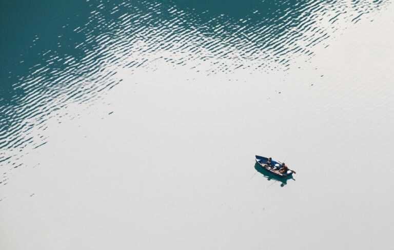 view of calm open water with a boat floating in the bottom right corner
